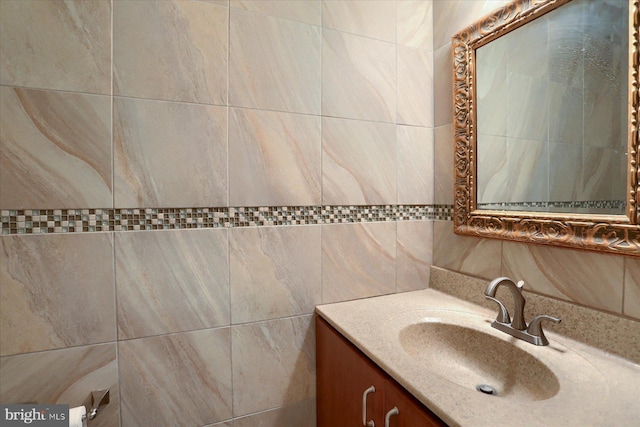 bathroom with vanity and tile walls