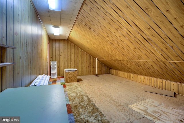 additional living space featuring wooden walls and vaulted ceiling