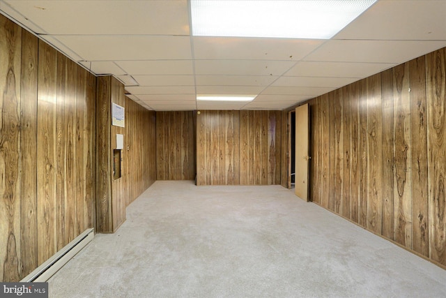 basement featuring a baseboard radiator, light colored carpet, and wood walls