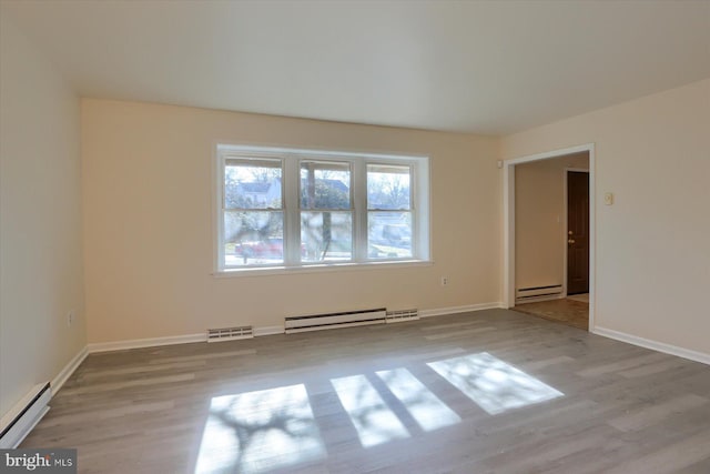 spare room with a baseboard radiator and light wood-type flooring