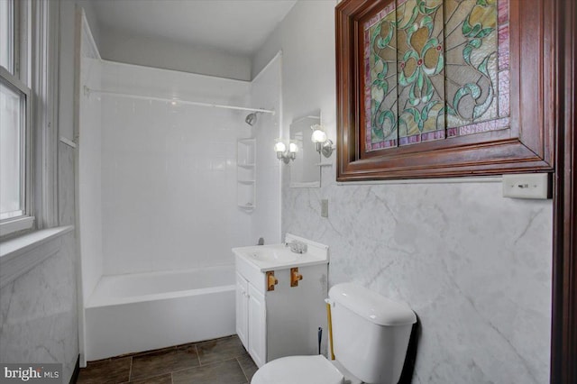 full bathroom featuring vanity, tiled shower / bath combo, and toilet