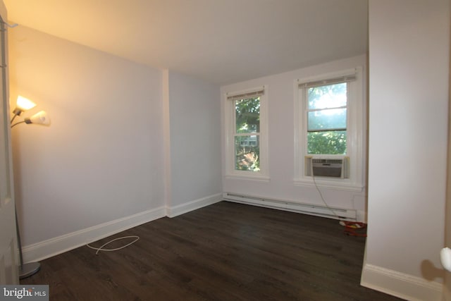 empty room featuring cooling unit, dark hardwood / wood-style flooring, and a baseboard heating unit