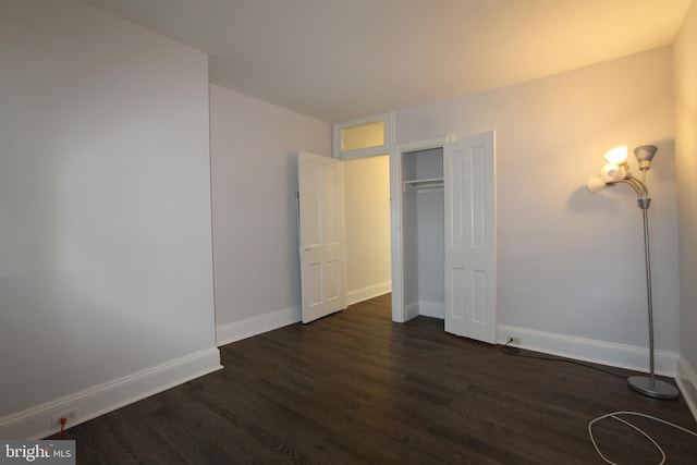 unfurnished bedroom featuring dark wood-type flooring and a closet