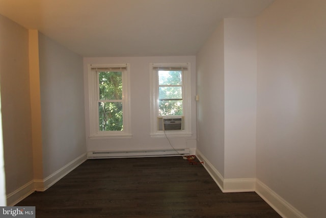 empty room featuring dark hardwood / wood-style floors and a baseboard heating unit