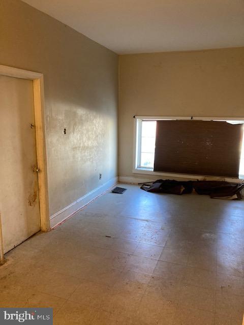 empty room with tile patterned floors, visible vents, and baseboards