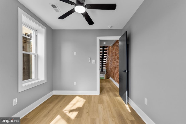 spare room featuring plenty of natural light, ceiling fan, and light hardwood / wood-style flooring