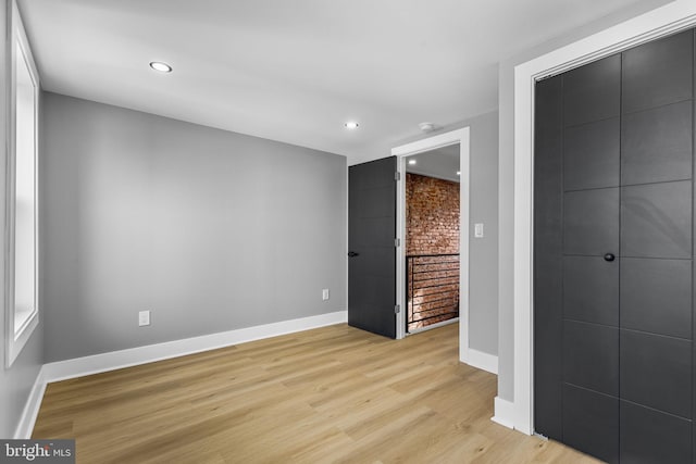 unfurnished bedroom featuring light hardwood / wood-style floors and a closet