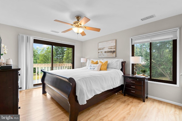 bedroom featuring multiple windows, ceiling fan, access to outside, and light wood-type flooring