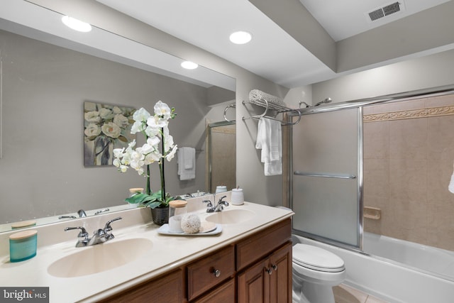 full bathroom with toilet, vanity, and bath / shower combo with glass door