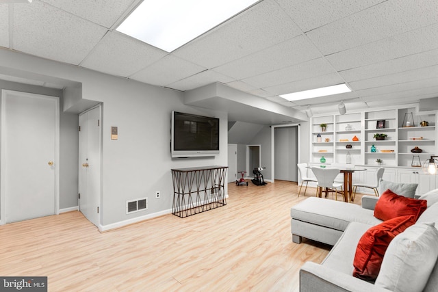 living room with a paneled ceiling and hardwood / wood-style floors