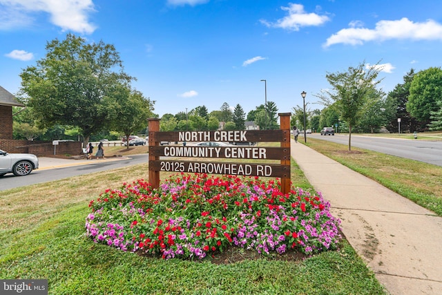 community / neighborhood sign featuring a yard