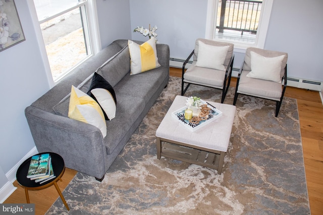 living room with dark wood-type flooring and a baseboard heating unit