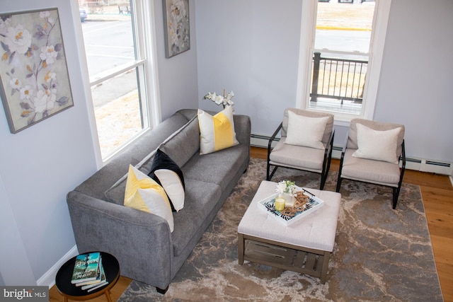 living room featuring a baseboard heating unit and dark hardwood / wood-style floors