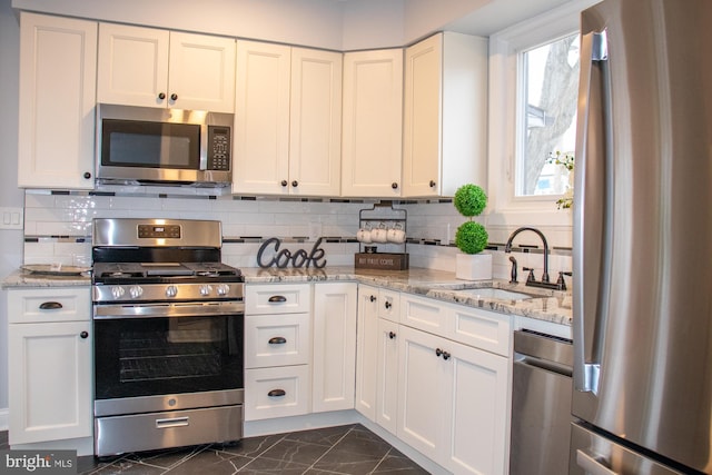 kitchen with appliances with stainless steel finishes, sink, and white cabinets