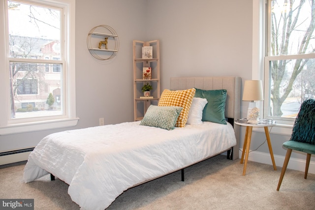 bedroom with light colored carpet and baseboard heating