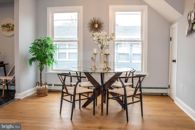 dining space featuring plenty of natural light, light hardwood / wood-style floors, and baseboard heating