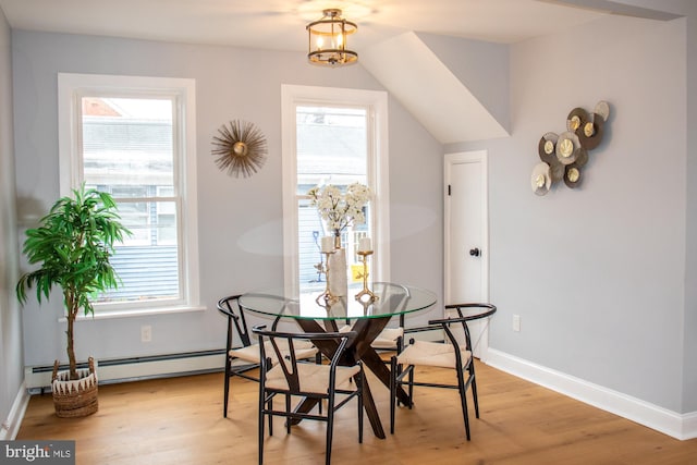 dining space featuring a notable chandelier, baseboard heating, and light hardwood / wood-style flooring