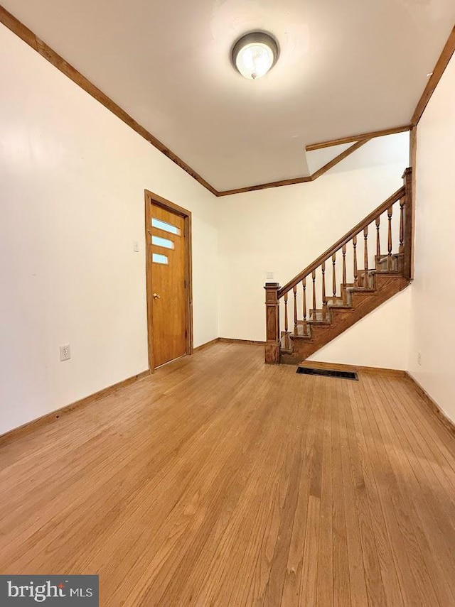 entryway featuring ornamental molding and light hardwood / wood-style floors