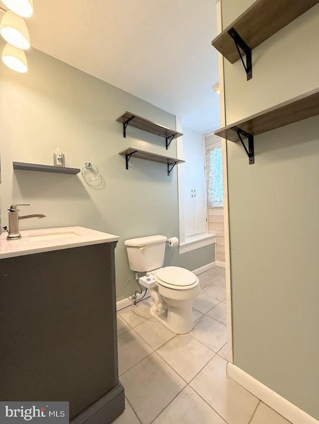 bathroom featuring tile patterned flooring, vanity, and toilet