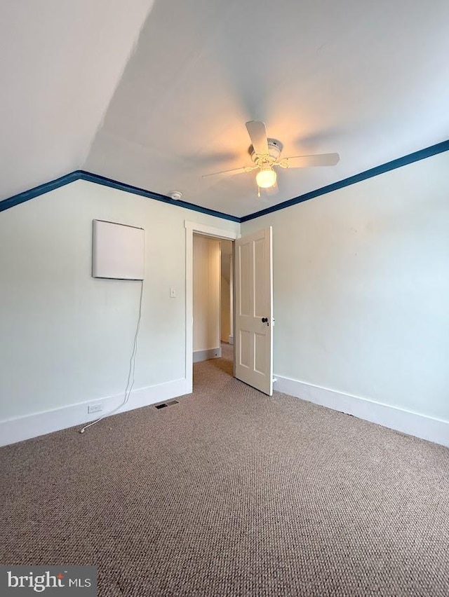 carpeted empty room with vaulted ceiling and ceiling fan