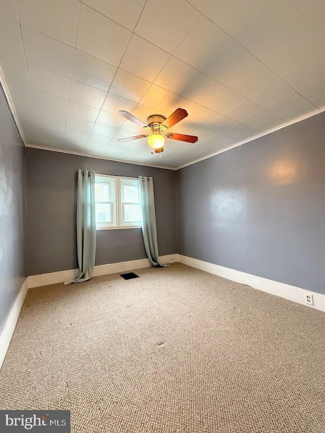 carpeted spare room with ornamental molding and ceiling fan