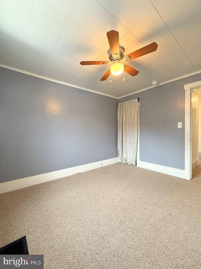 carpeted spare room with crown molding and ceiling fan