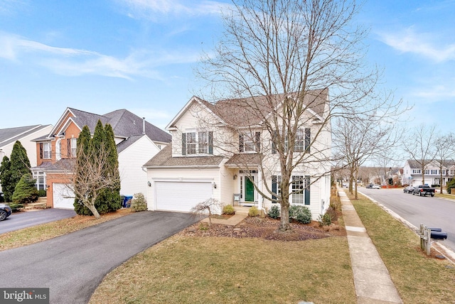 traditional home featuring a garage, a residential view, driveway, and a front lawn