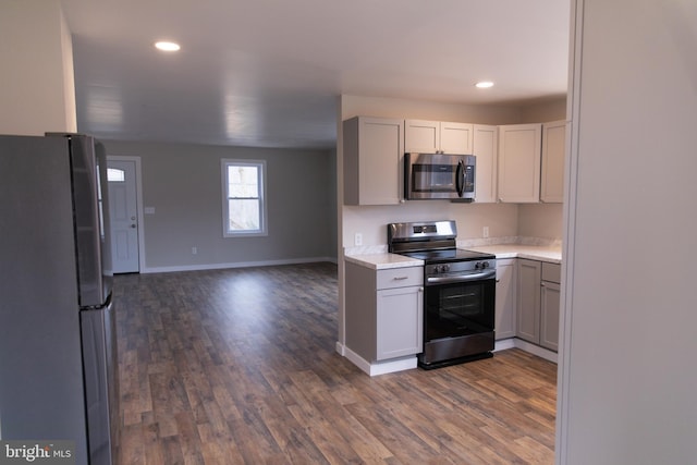 kitchen with dark hardwood / wood-style flooring, gray cabinets, and appliances with stainless steel finishes