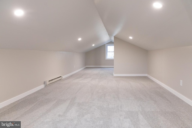 bonus room featuring lofted ceiling, a baseboard radiator, and light colored carpet