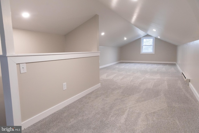 bonus room featuring vaulted ceiling, a baseboard heating unit, and light colored carpet