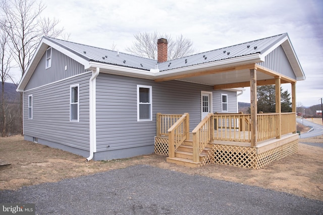 rear view of property featuring a wooden deck