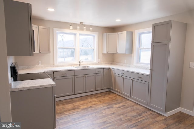 kitchen with gray cabinets, stove, sink, and plenty of natural light