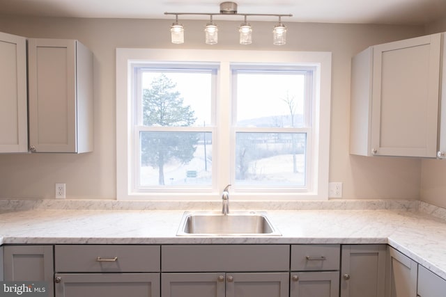 kitchen featuring pendant lighting, sink, and gray cabinetry