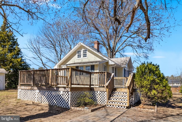 back of property featuring a wooden deck and a chimney