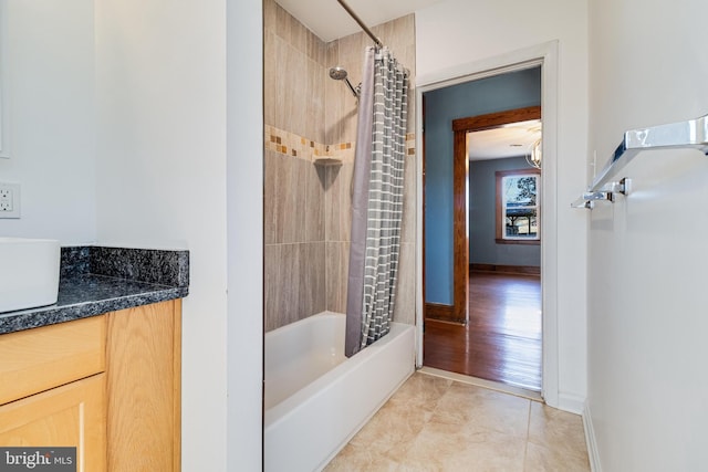 full bathroom featuring tile patterned floors, shower / bathtub combination with curtain, baseboards, and vanity