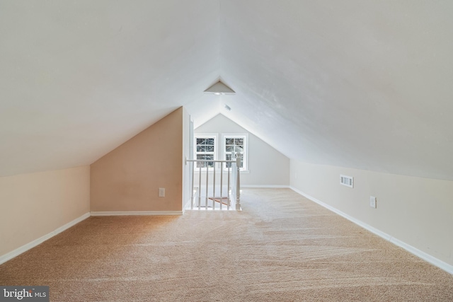 bonus room featuring lofted ceiling, carpet flooring, baseboards, and visible vents