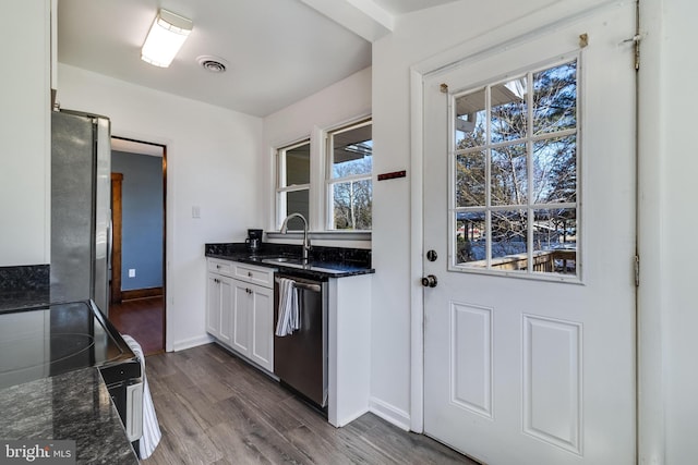 kitchen featuring visible vents, dark wood-type flooring, a sink, white cabinetry, and stainless steel appliances