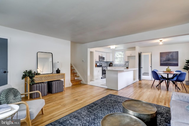 living room with sink and light wood-type flooring