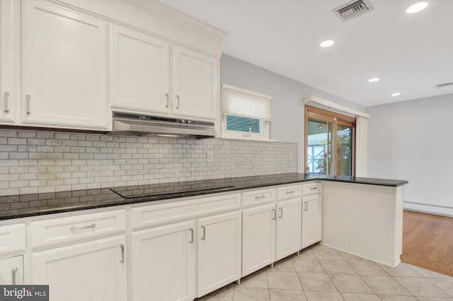 kitchen with white cabinetry, black electric stovetop, and dark stone counters