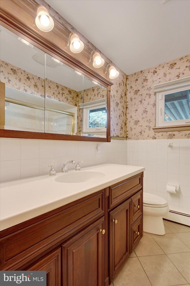 bathroom featuring tile walls, tile patterned flooring, vanity, a baseboard heating unit, and toilet