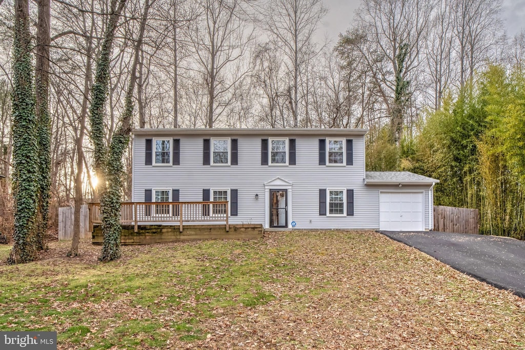 colonial home with a garage and a front yard