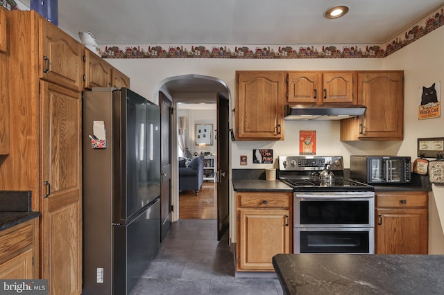 kitchen with black refrigerator and range with two ovens