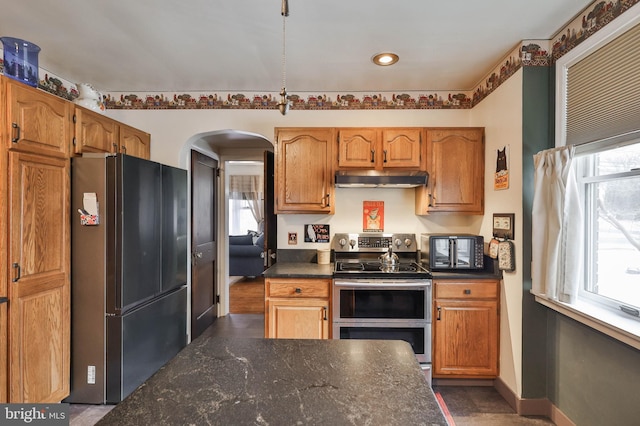 kitchen with black fridge, double oven range, and a wealth of natural light