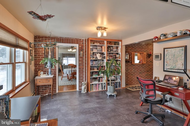 home office featuring a healthy amount of sunlight and brick wall