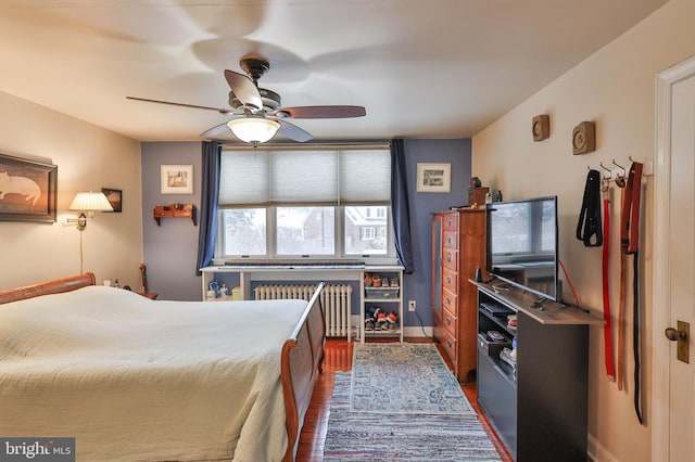 bedroom featuring dark wood-type flooring, radiator heating unit, and ceiling fan