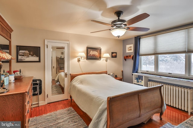 bedroom with dark wood-type flooring, radiator heating unit, and ceiling fan