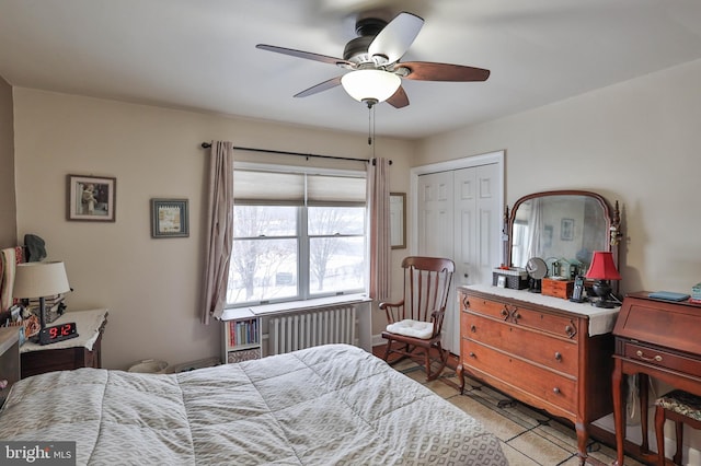 bedroom with radiator heating unit, ceiling fan, and a closet