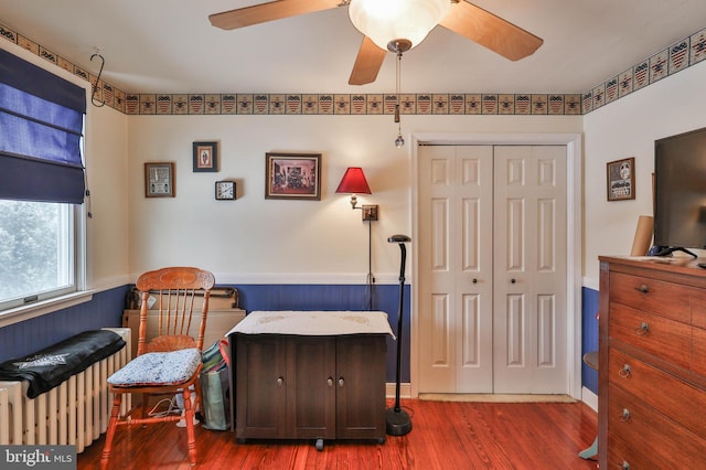 sitting room with radiator, hardwood / wood-style floors, and ceiling fan