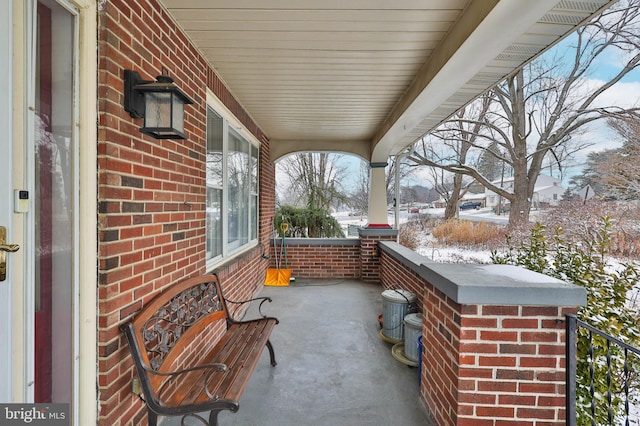 snow covered patio with a porch