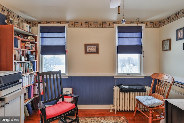 living area featuring hardwood / wood-style flooring and radiator heating unit